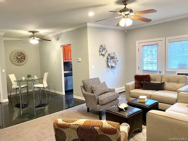 a living room with furniture a couch and chandelier fan