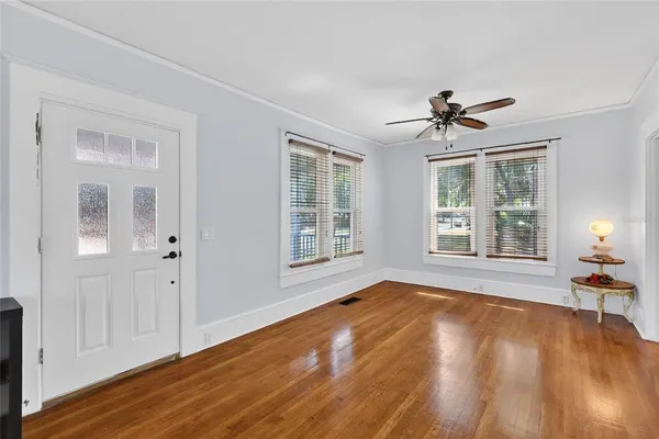 a view of empty room with wooden floor and fan