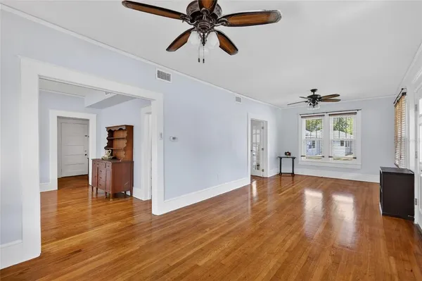 a view of a livingroom with wooden floor and a ceiling fan