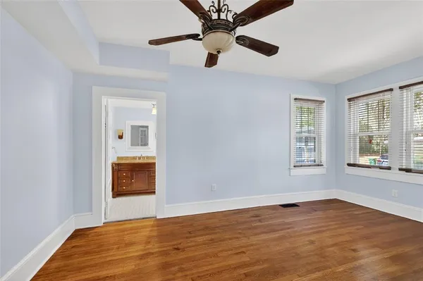 a view of an empty room with a window and wooden floor