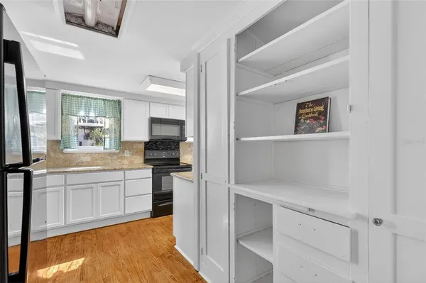 a large white kitchen with cabinets