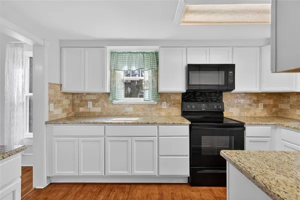 a kitchen with stainless steel appliances granite countertop a stove sink and microwave