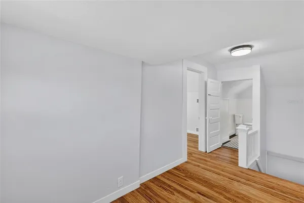 a view of a room with wooden floor and white walls