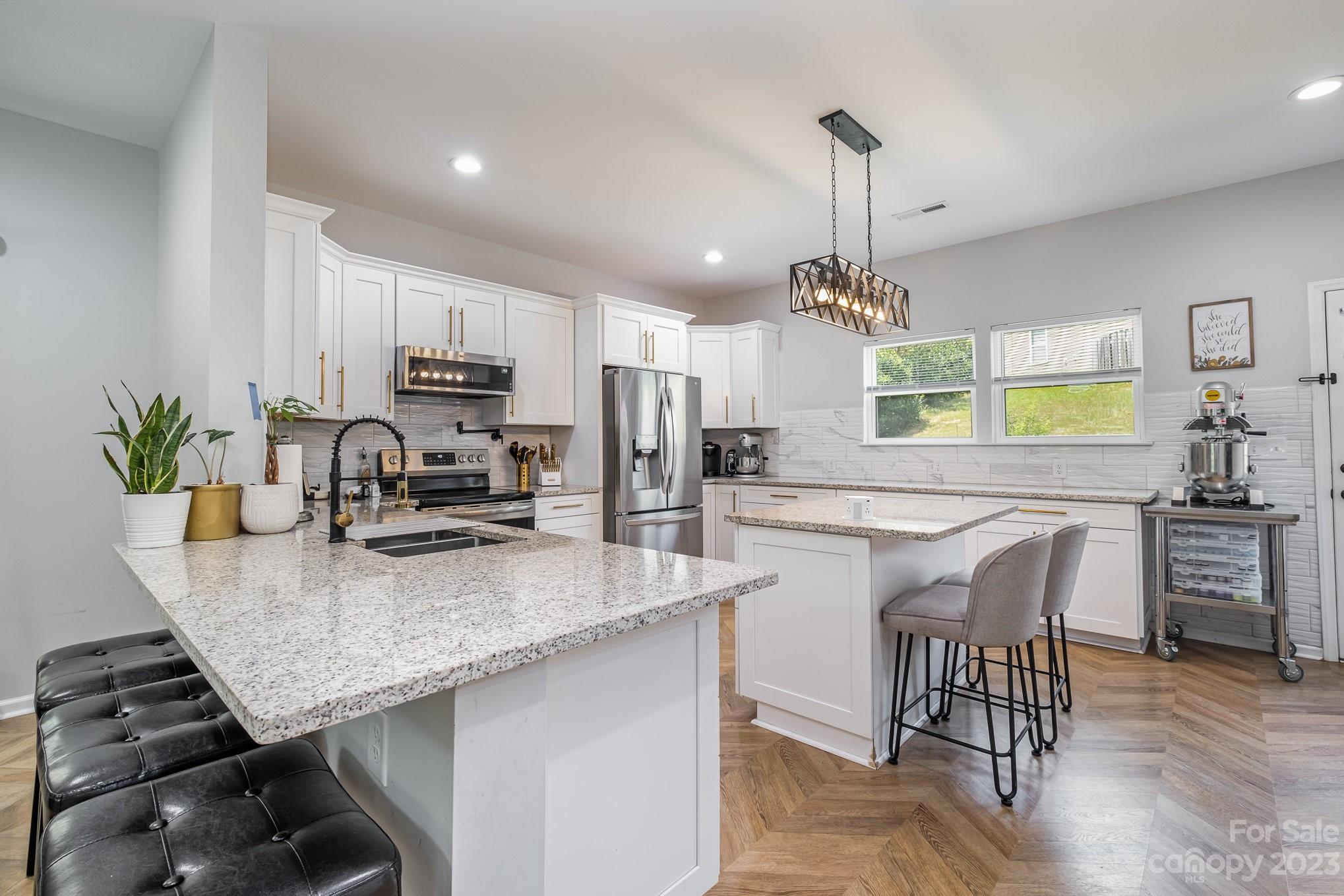 2213 Turtle Point Road Charlotte, NC 28262 - Photo 10 of 28 a kitchen with kitchen island granite countertop a stove a sink a oven a counter space and dining table