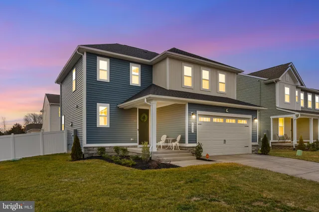 a kitchen with stainless steel appliances kitchen island granite countertop a sink a stove a refrigerator and white cabinets with wooden floor