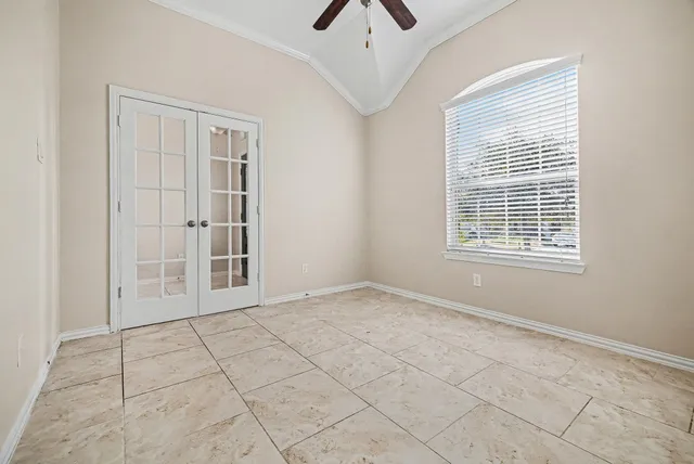 a view of an empty room with chandelier fan and fire place
