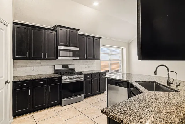 a kitchen with wooden cabinets a sink and a stove