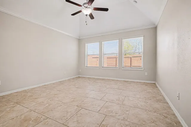 an empty room with windows and fan