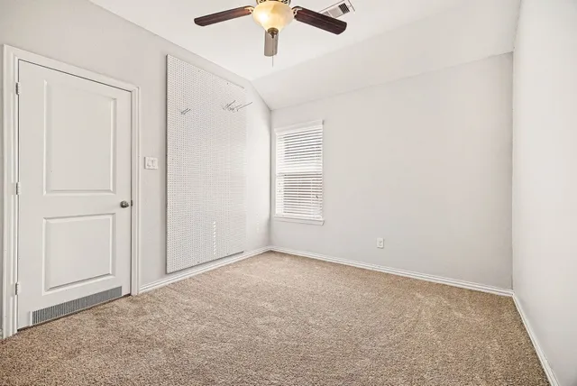an empty room with a window and a ceiling fan
