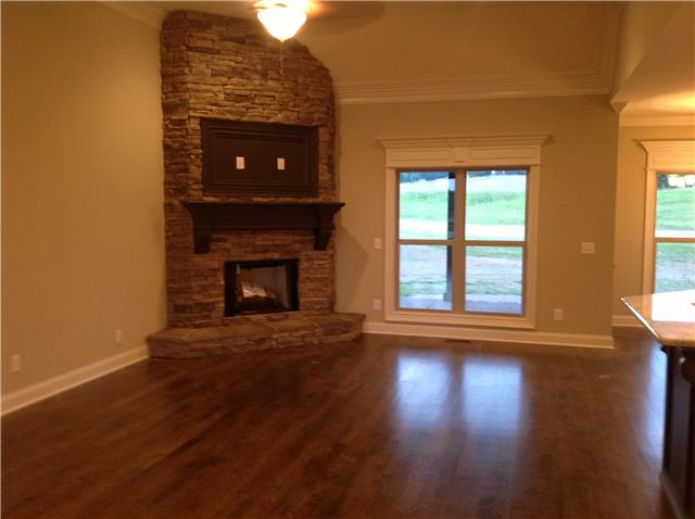 821 Double Log Cabin Road Lebanon, TN 37087 - Photo 11 of 16 a view of an empty room with wooden floor fireplace and a window