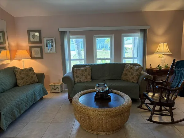 a living room with furniture a lamp a window and a flat screen tv