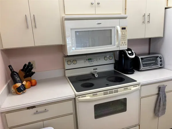 a kitchen with a stove and white cabinets