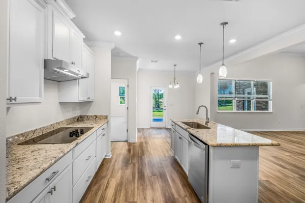 a kitchen with stainless steel appliances granite countertop a sink stove and cabinets
