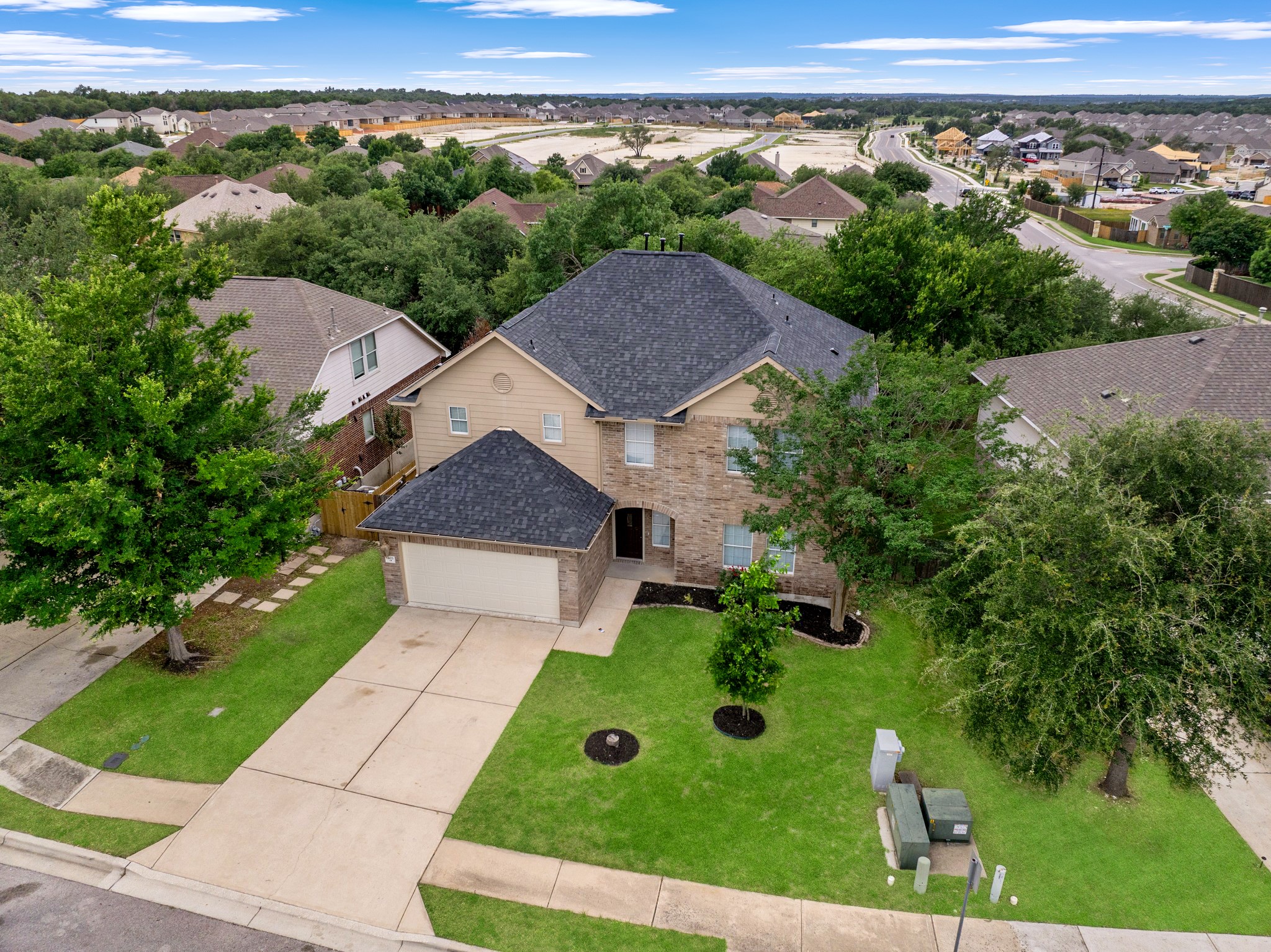 403 Red Hawk Drive Leander, TX 78641 - Photo 33 of 37 Two-story residence featuring brick and siding exterior, a two-car garage, and a dark shingle roof