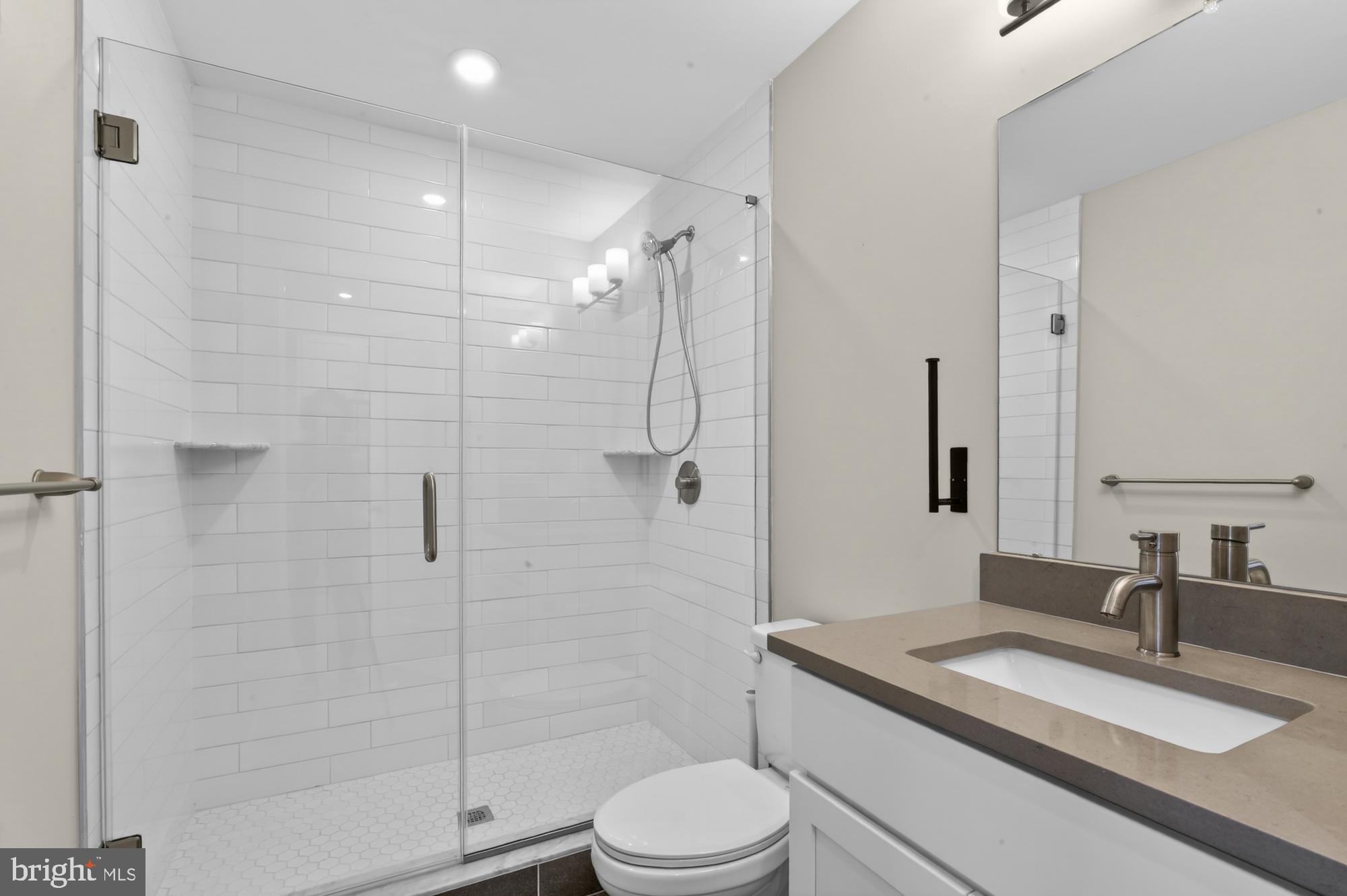 5230 Walnut Street, Unit 2F Philadelphia, PA 19139 - Photo 12 of 21 a bathroom with a granite countertop sink toilet and shower