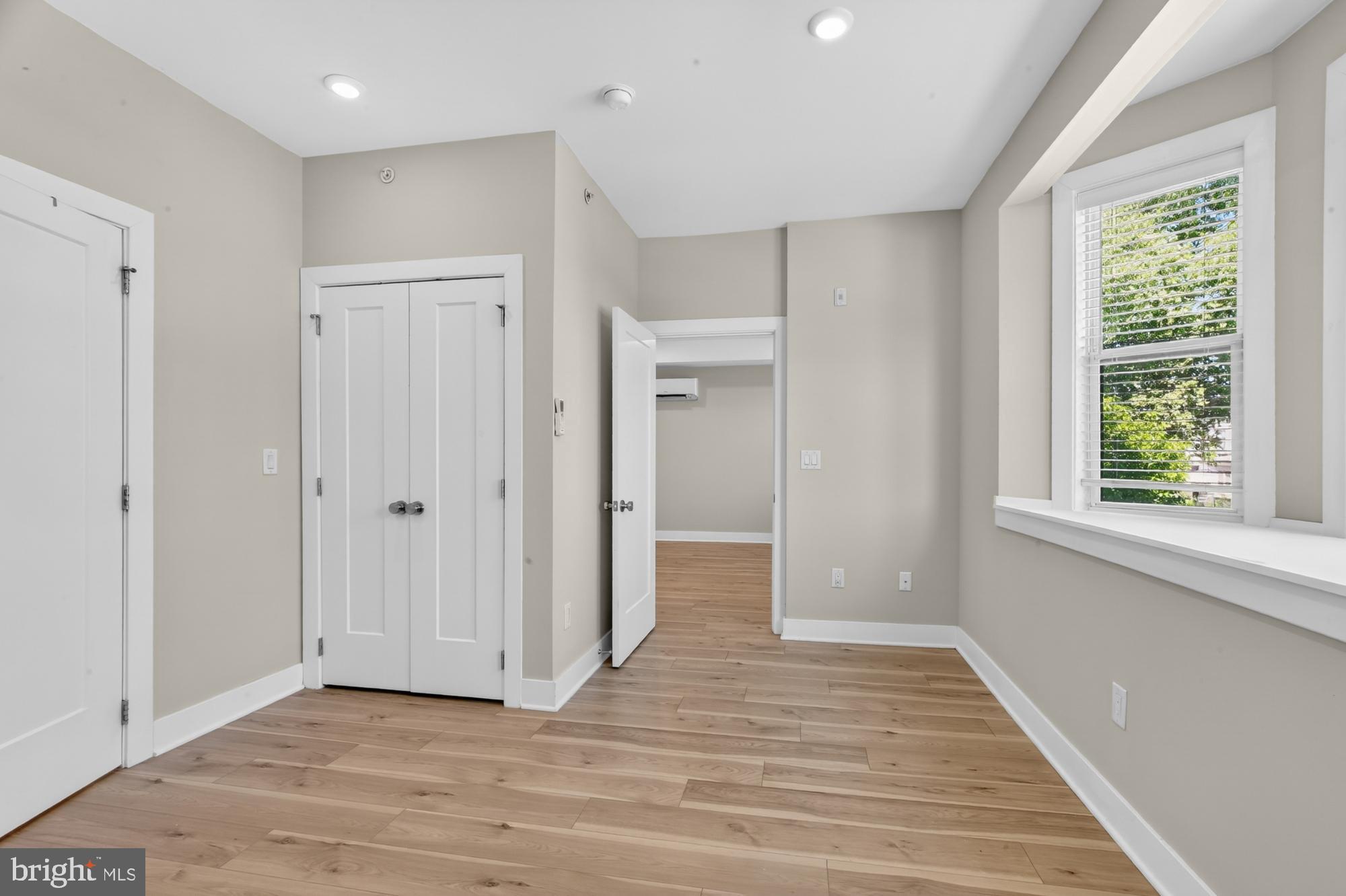 5230 Walnut Street, Unit 2F Philadelphia, PA 19139 - Photo 14 of 21 a view of an empty room with wooden floor and a window