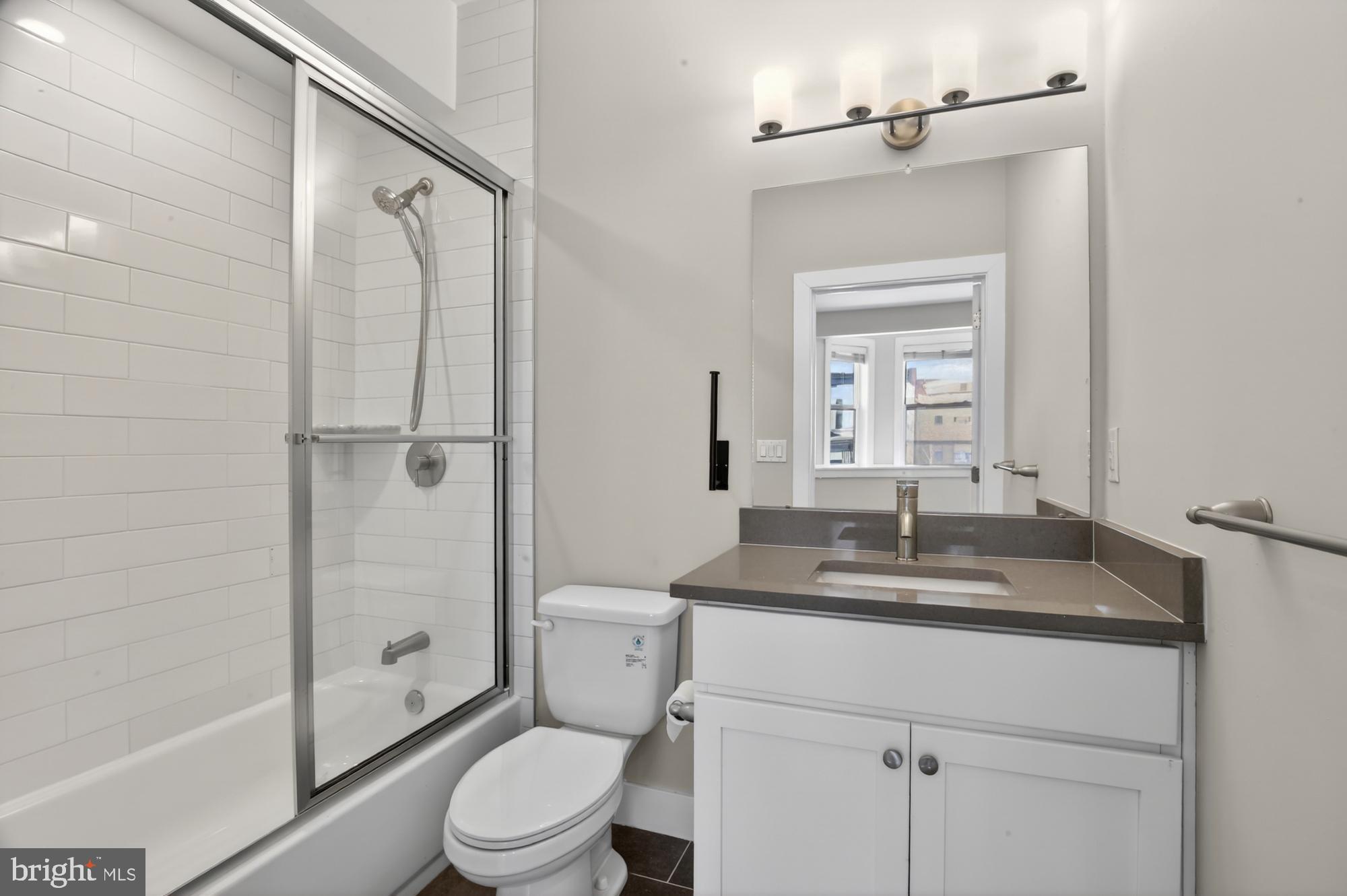 5230 Walnut Street, Unit 2F Philadelphia, PA 19139 - Photo 17 of 21 a bathroom with a granite countertop sink toilet and shower