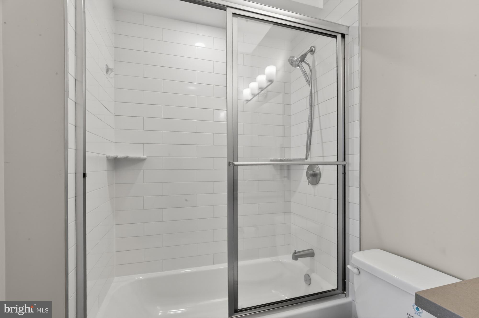5230 Walnut Street, Unit 2F Philadelphia, PA 19139 - Photo 18 of 21 a bathroom with a glass shower door