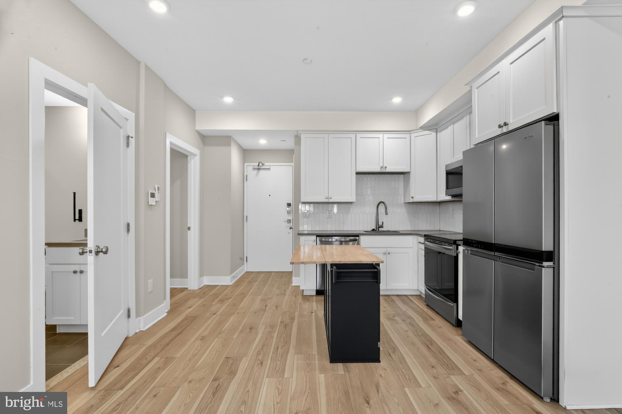 5230 Walnut Street, Unit 2F Philadelphia, PA 19139 - Photo 3 of 21 a kitchen with a refrigerator a sink and dishwasher with wooden floor