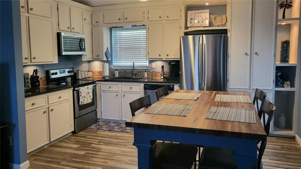 a kitchen with stainless steel appliances granite countertop a stove refrigerator sink and cabinets