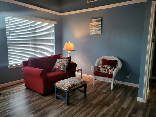a living room with furniture a window and a wooden floor