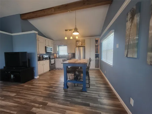 a dining room with furniture a chandelier and wooden floor
