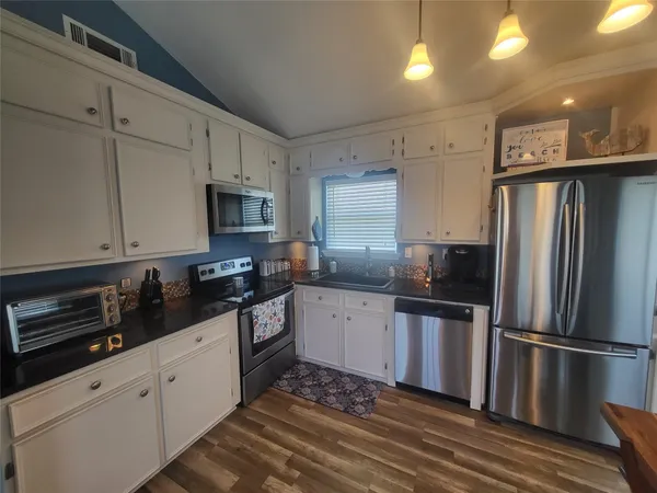 a kitchen with granite countertop a refrigerator stove and sink