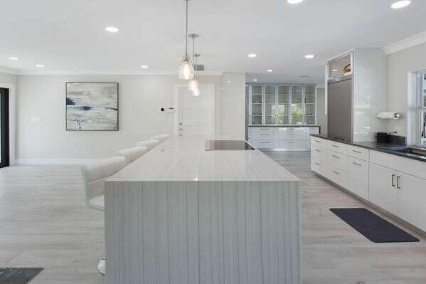 839 Enfield Street Boca Raton, FL 33487 - Photo 8 of 36 a large white kitchen with a large island oven a sink stainless steel appliances and cabinets