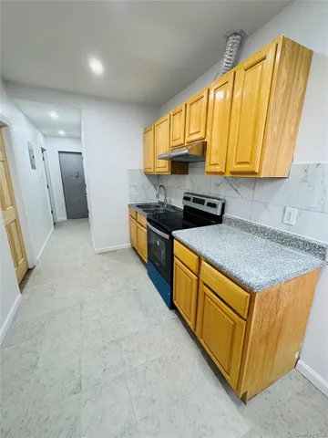 a kitchen with stainless steel appliances granite countertop a sink a stove and a refrigerator
