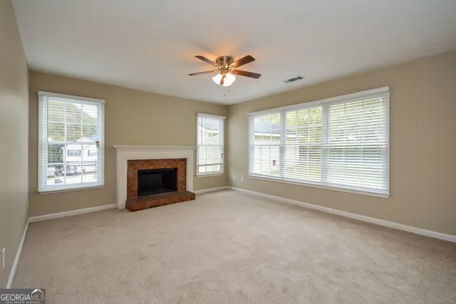 a view of a livingroom with a ceiling fan and fireplace