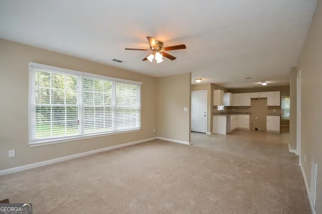 a view of a livingroom with a ceiling fan and window