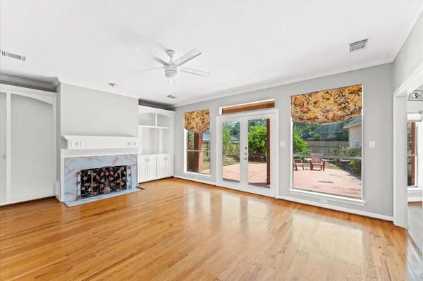 a view of an empty room with a window and wooden floor