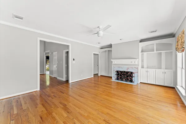 a view of a livingroom with wooden floor and a ceiling fan