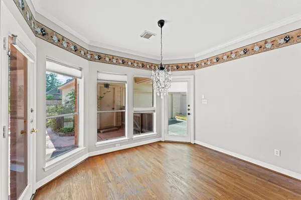 a view of a room with wooden floor fan and windows