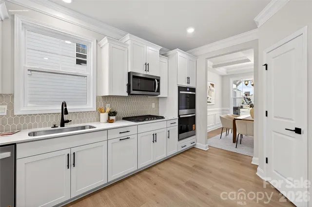 a kitchen with a sink cabinets and wooden floor