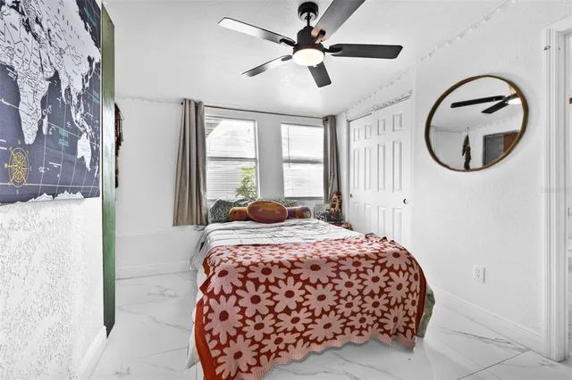 a bedroom with a large bed and a chandelier