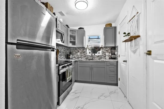 a kitchen with stainless steel appliances a refrigerator sink and cabinets