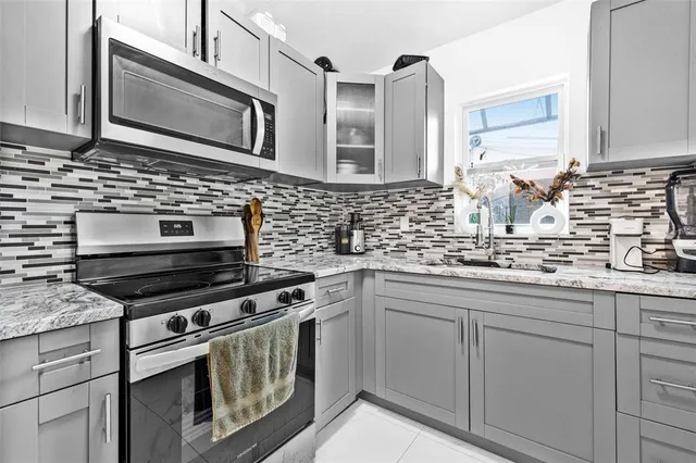 a kitchen with stainless steel appliances a stove sink and microwave