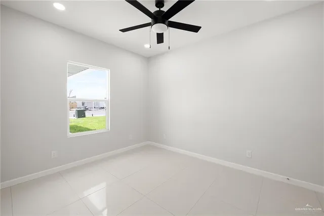 an empty room with a window and a ceiling fan