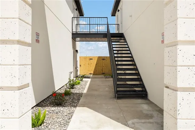 a view of a hallway with wooden floor and stairs