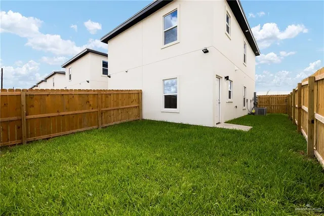a view of backyard with barbeque grill potted plants and wooden fence