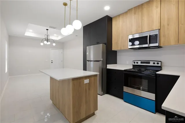 a kitchen with stainless steel appliances granite countertop a refrigerator a stove a sink and a microwave