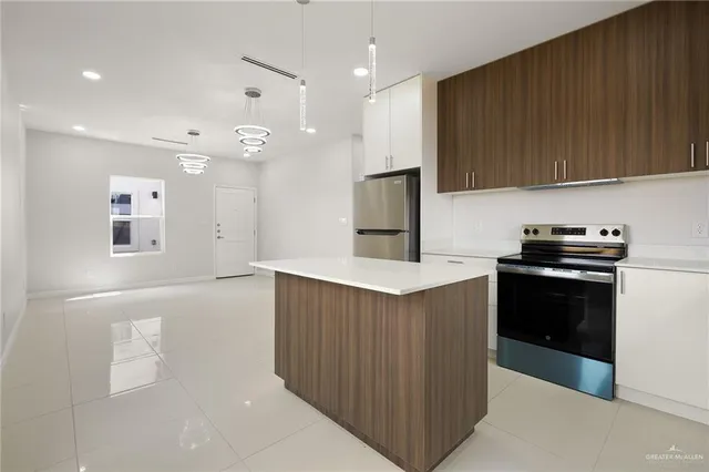 a kitchen with kitchen island a sink stainless steel appliances and cabinets