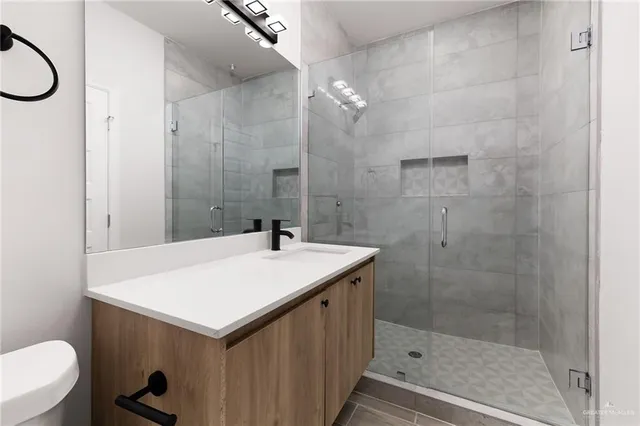 a bathroom with a sink a toilet and shower