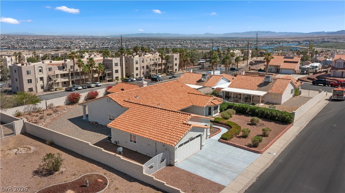 2055 Cholla Way Laughlin, NV 89029 - Photo 85 of 87 An aerial perspective reveals a desert-landscaped front yard with mature shrubbery and a private attached garage.