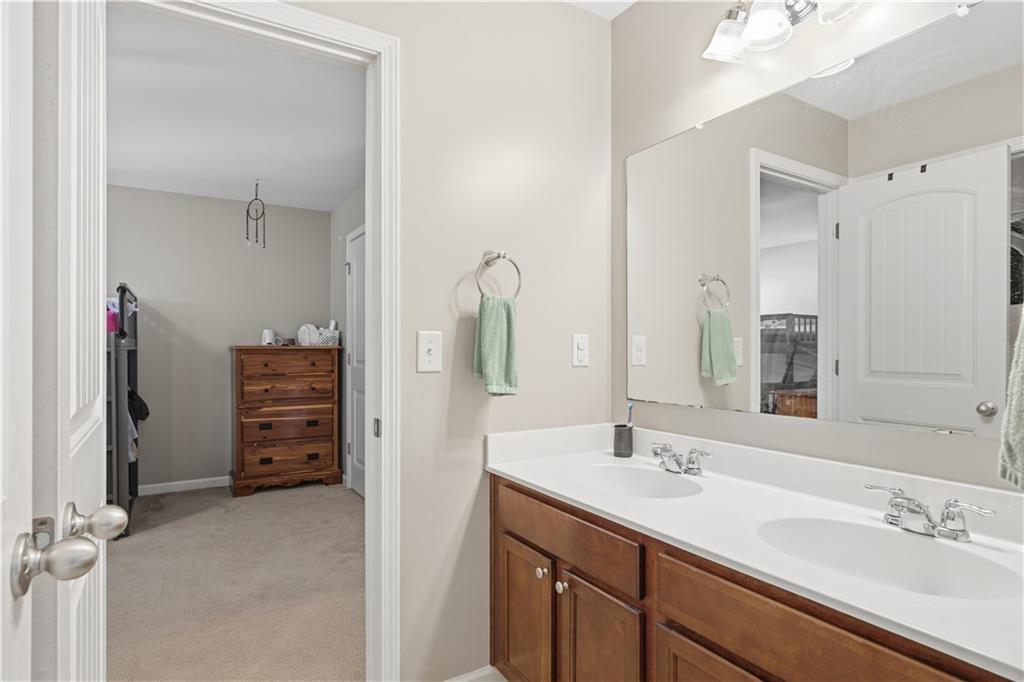 5825 Willow Oak Pass Cumming, GA 30040 - Photo 32 of 55 a bathroom with a double vanity sink and mirror