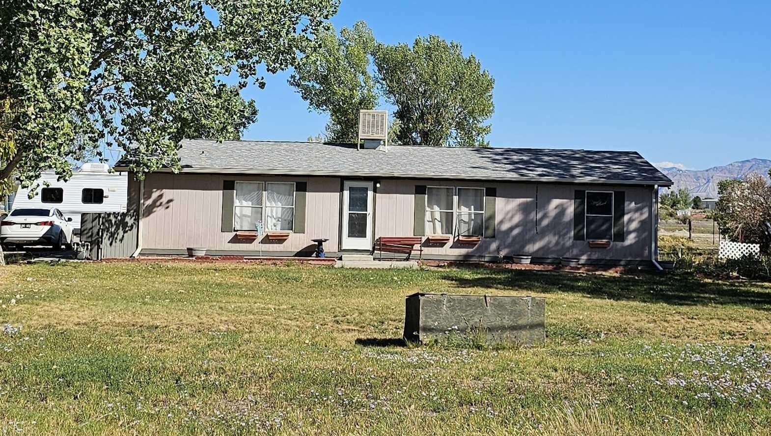 a view of a house with backyard and sitting area