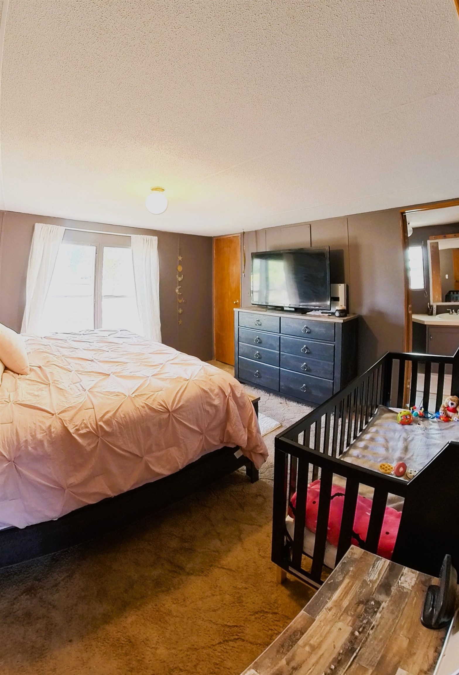 2108 1/2 H Road Fruita, CO 81521 - Photo 24 of 40 a bedroom with a bed and a chandelier