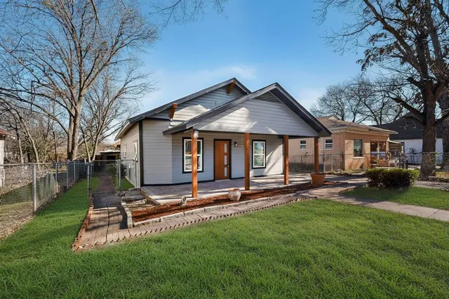 a front view of a house with a garden and yard