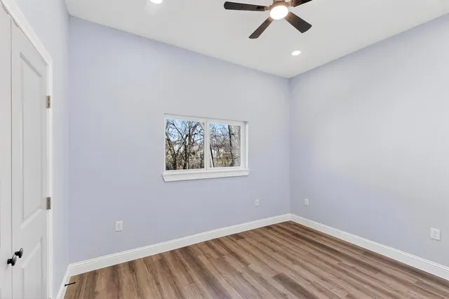 an empty room with a ceiling fan and carpet